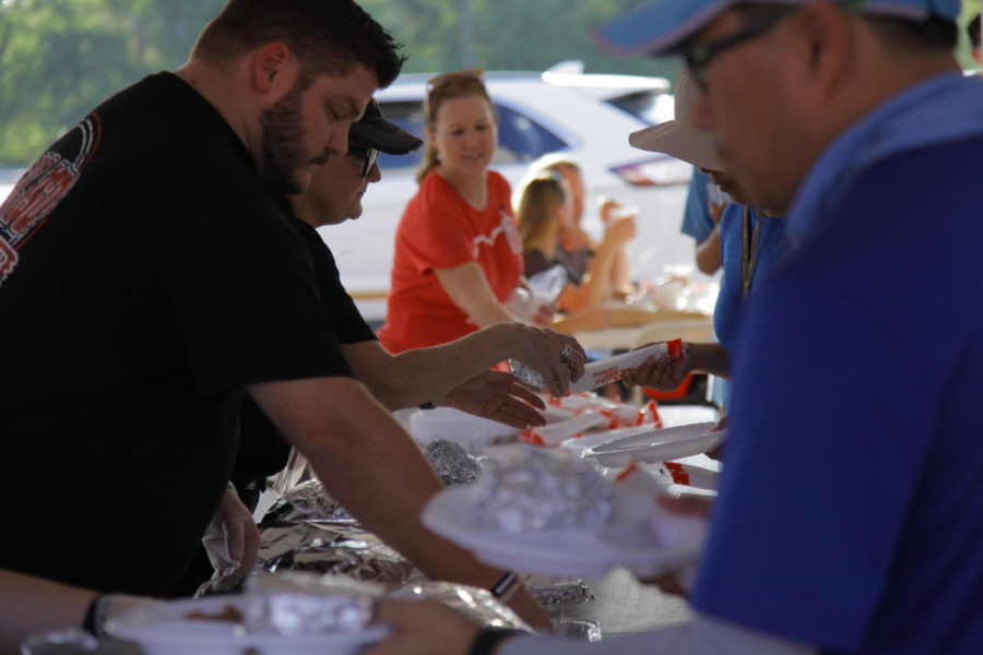 CHS9 Principal Cody Koontz serves food to parents, teachers and children. Coppell ISD hosted its home game tailgate in the Buddy Echols Field parking lot on Friday before the football game against Hebron.