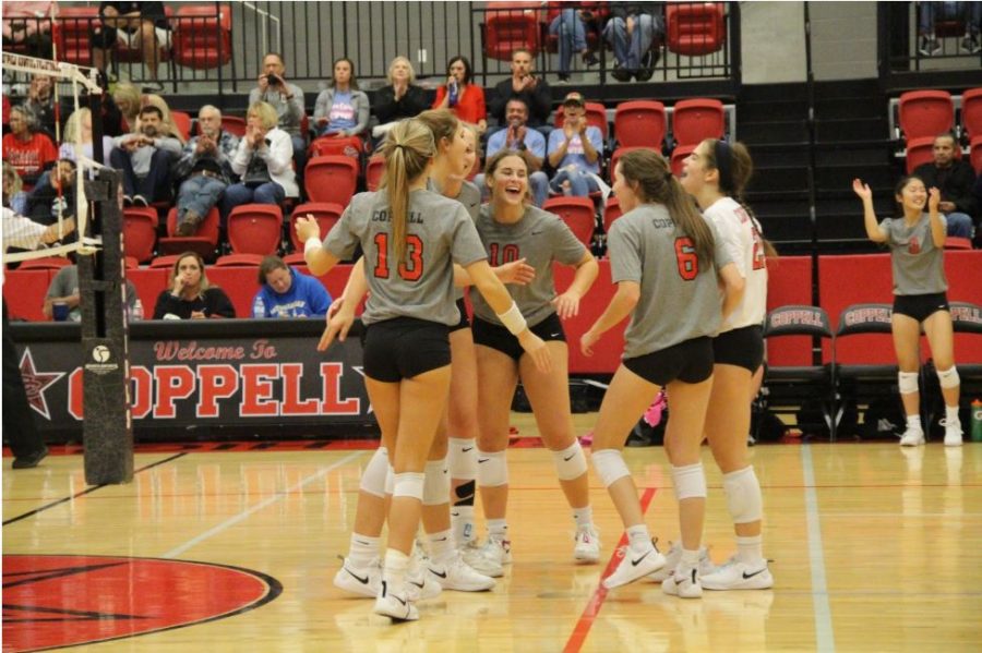 The+Coppell+volleyball+team+celebrate+its+victory+in+the+CHS+Arena+on+Friday.+Coppell+defeated+Lewisville%2C+3-0.