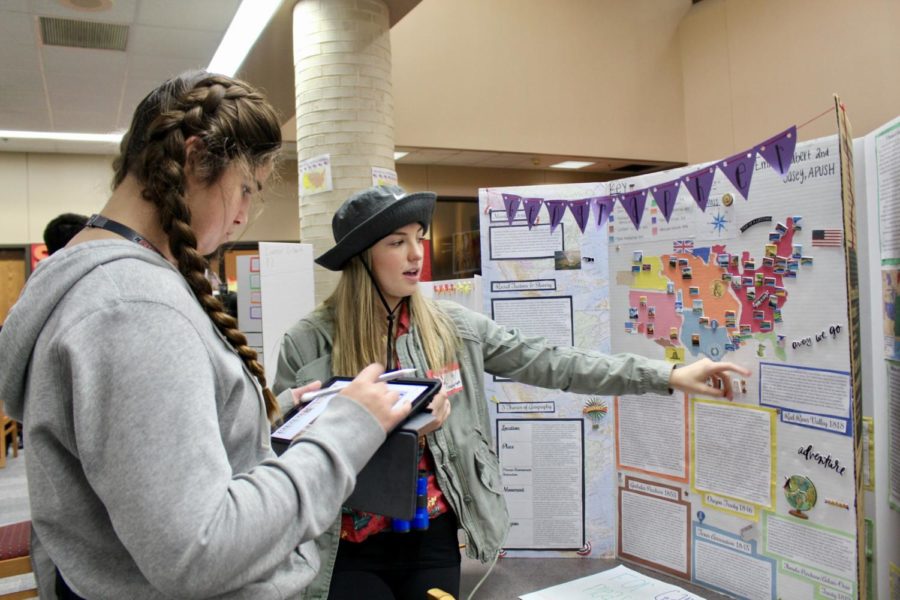 Coppell High School junior Emma Hubert presents to CHS junior Harmony Charles as a physical geographer for the We Are One project during second period AP U.S. history on Wednesday. Students used their skills to take on jobs from the Antebellum period between the War of 1812 and the Civil War.