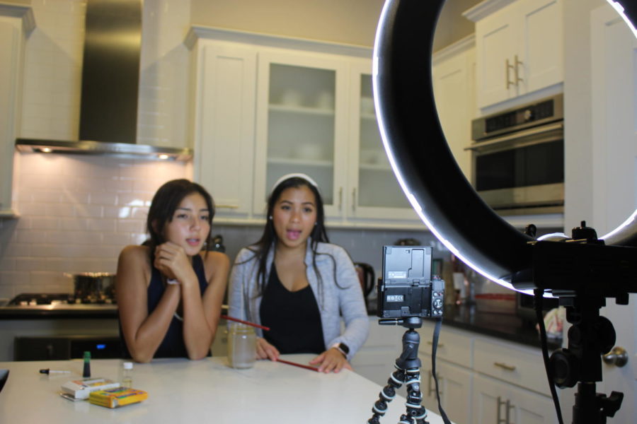 With help from her cousin, Ranchview High School sophomore Emma Immanivong (left), Coppell High School senior Alyson Immanivong films a DIY fall candle video on Oct. 7 for her YouTube channel. Immanivong posts videos every Wednesday on her channel that has more than 500 subscribers. 