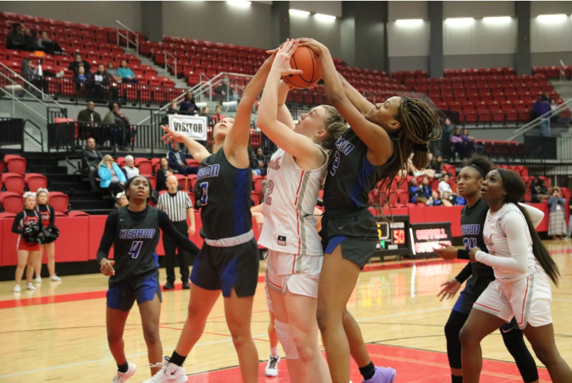 Coppell+freshman+Reagan+Engler+attempts+to+block+the+ball+from+two+Hebron+players.+The+Cowgirls+lost+to+the+Hebron+Hawks+53-44.