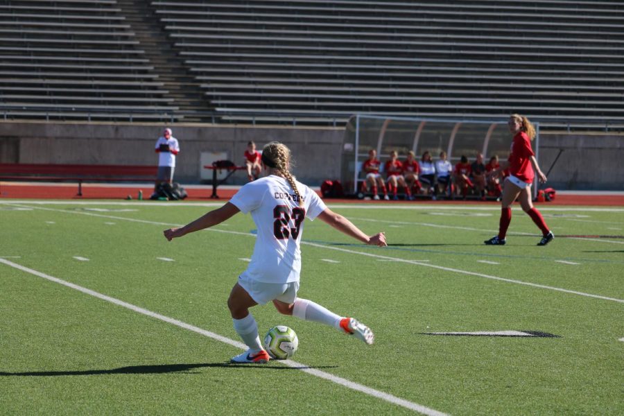 Coppell+sophomore+defender+Bailey+Peek+crosses+a+free+kick+into+the+box+on+Saturday+at+Buddy+Echols+Field.+The+Coppell+Cowgirls+defeated+the+Lady+Tigers%2C+2-0.