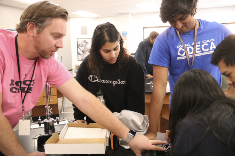 Coppell High School physics teacher and assistant baseball coach Clint Rushing assists CHS seniors Sophia Raza, Devan Patel, Andrew Tao and Vanuli Arya construct a working circuit board during his third period on Dec. 4. Rushing has taught at CHS for 11 years and was named The Sidekick’s December teacher of the issue.