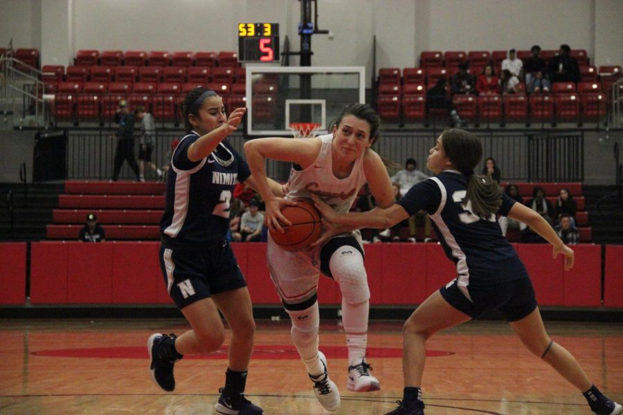 Coppell+senior+guard+Megan+O%E2%80%99Neil+drives+against+Irving+Nimitz+guards+Jocelyn+De+la+Garza+and+Britney+Gonzalez+yesterday+at+the+CHS+Arena.+The+Cowgirls+defeated+Nimitz%2C+79-38.