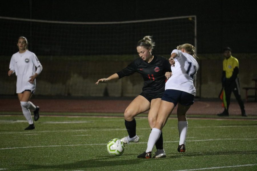 Coppell junior defender Emma Hubert fights for possession from Flower Mound senior midfielder Caitlin Matthews on Friday at Buddy Echols Field. The Cowgirls fell to Flower Mound, 1-0. 