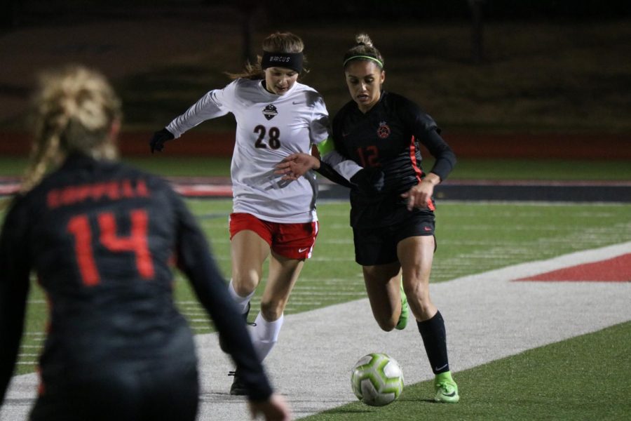 Marcus midfielder/forward Kelly Van Gundy and Coppell junior left forward Jojo Alonzo run to take possession on Tuesday at Buddy Echols Field. Despite an offensive surge in the second half, the Cowgirls fell to the Marauders, 3-2.