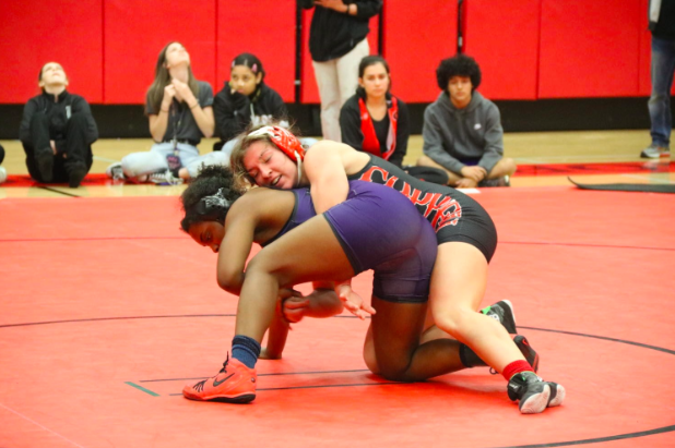 New Tech High @ Coppell senior captain Brooke Massaviol wrestles in top position against Frisco Independence junior Sariah Ferguson at the Knockout Sportswear Cowgirl Classic on Dec. 6 in the CHS Arena. Massaviol has qualified for today and tomorrow’s UIL State Wrestling Championship after placing third in the 148 pound weight class in the Class 6A Region II Championship match.