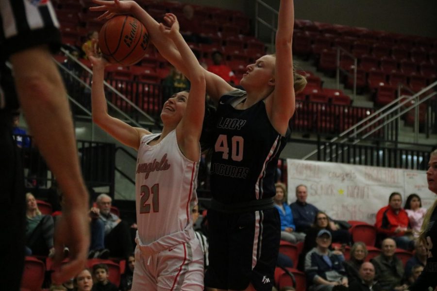 Coppell senior guard Megan O’Neil goes up for a layup but is blocked by Flower Mound freshman post Emily Curl last night at the CHS Arena. The Cowgirls fell to the Jaguars, 64-30.