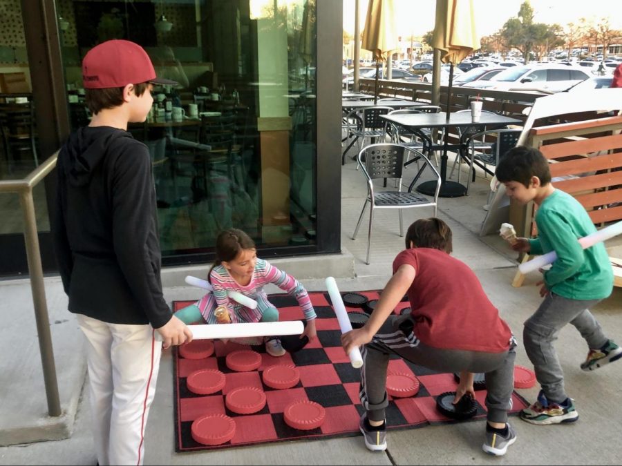 Kids play life size checkers at the pop up party at JC’s Burger Bar on Thursday night. Coppell ISD is hosting pop up parties around the city to celebrate its 60th anniversary. 