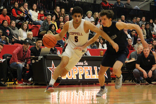 Coppell senior guard Adam Moussa dribbles around Flower Mound senior Preston Evans yesterday at the CHS Arena. The Cowboys defeated the Jaguars, 66-56.