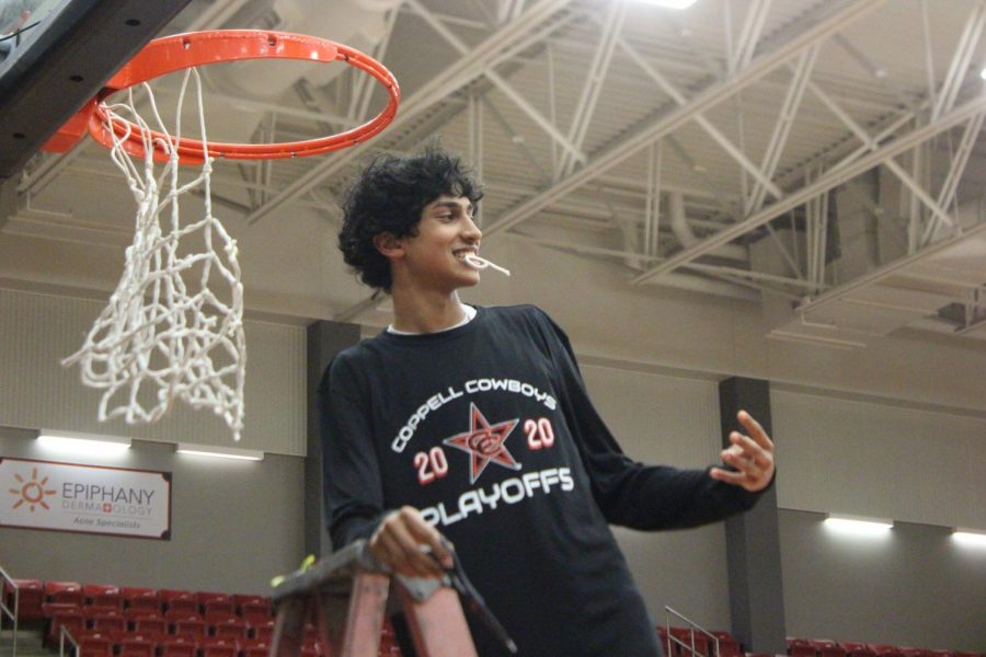 Coppell+sophomore+guard+Ryan+Agarwal+puts+a+piece+of+net+in+his+mouth+to+celebrate+the+Cowboy%E2%80%99s+District+6-6A+title.+The+Cowboys+open+the+Class+6A+playoffs+against+Eaton+at+Euless+Trinity+High+School+tomorrow+at+7+p.m.+