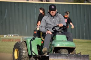 Coppell coach Mike Dyson rakes the infield at the Coppell ISD Softball Complex on March 7, following the Cowgirls’ victory over Cedar Hill, 7-5, at the Coppell & Marcus Tournament. Dyson is in his fifth year of coaching the Coppell softball team.
