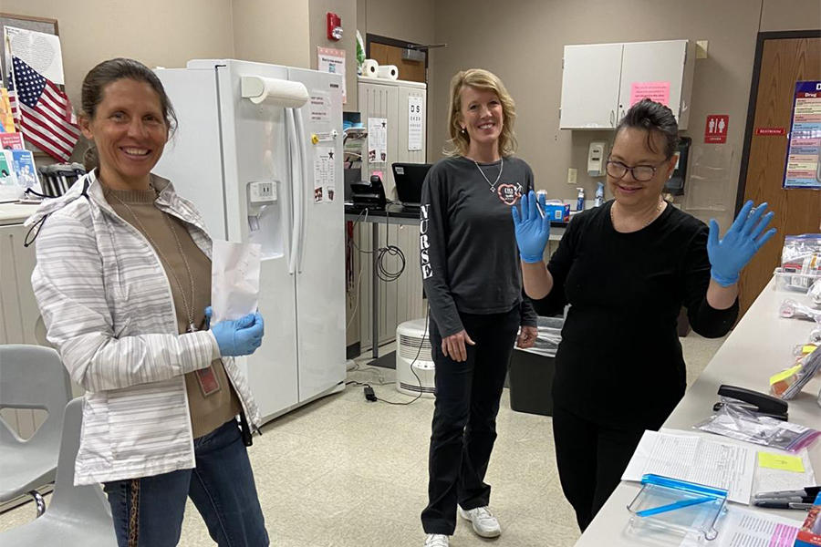 Coppell High School finance secretary Patcee Becerra, nurse Beth Dorn and clinic aide Jane Signore convene in the CHS clinic on March 20. Dorn has been working at CHS since 2006, experiencing many injury cases of students. 