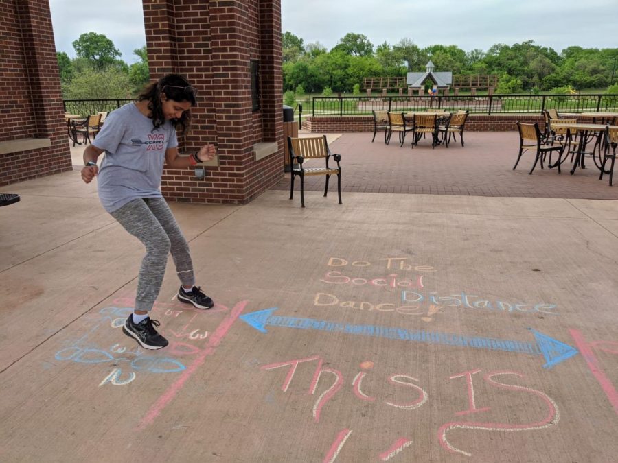 Coppell High School sophomore Dia Atluri follows chalk instructions for the social distance dance on the pavilion floor in Andrew Brown Park East on April 2. Coppell residents are using the extra time provided by the Dallas County issued stay-at-home order to draw colorful chalk messages around the community.