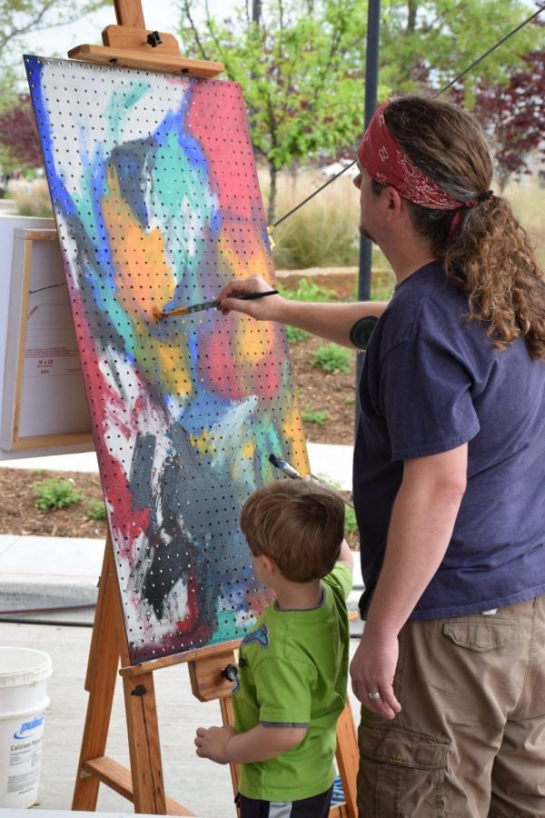 Coppell High School Art I, Honors Art I and Sculpture II teacher David Bearden paints with his son, Oliver, during the Colorpalooza arts festival in Lewisville in April 2019. Bearden’s teaching experience and love for creating art impact his students and his classroom environment. 