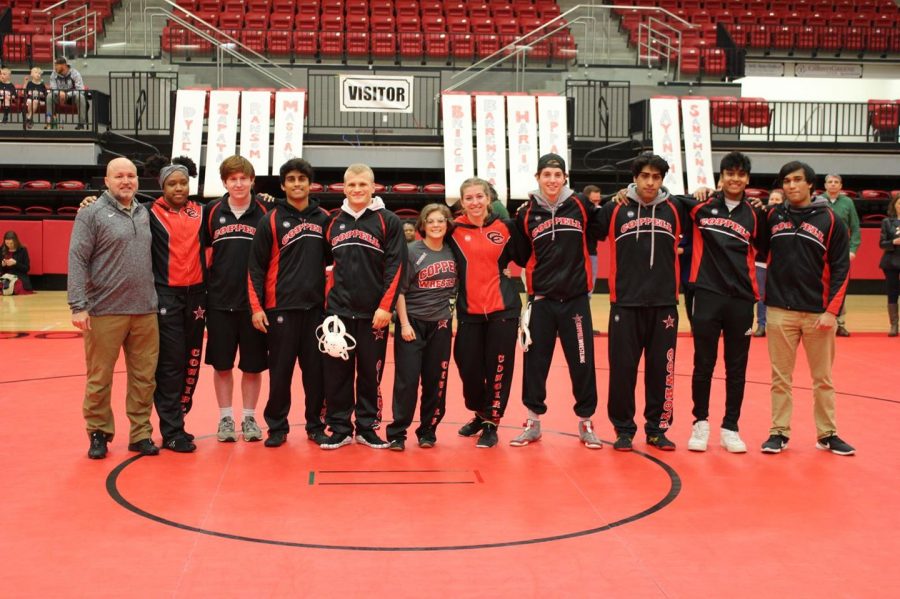 Coppell wrestling coach Chip Lowery (far left) takes a photo with senior wrestlers on Senior Night at the CHS Arena on Jan. 31. Lowery is also the physical education and dance department chair and off campus P.E. director. 