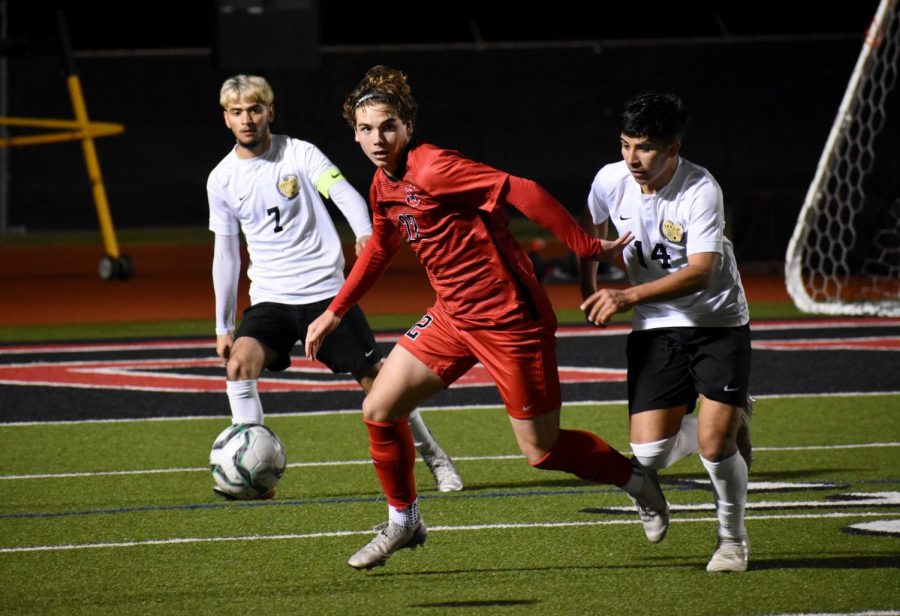 Coppell+senior+forward+Sebastian+Blaas+avoids+the+grasp+of+Irving+MacArthur+to+make+a+pass+on+Feb.+7.+Blaas+is+one+of+13+Cowboys+to+be+selected+for+a+District+6-6A+award.+