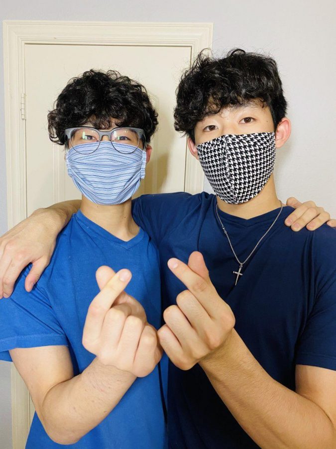 Coppell freshman Jacob Hahm and his brother Connections Academy junior Joshua wear masks and display the Korean symbol of love. Over six weeks, the Hahm family has made and donated more than 2,000 masks to local hospitals to help medical professionals during the coronavirus pandemic.