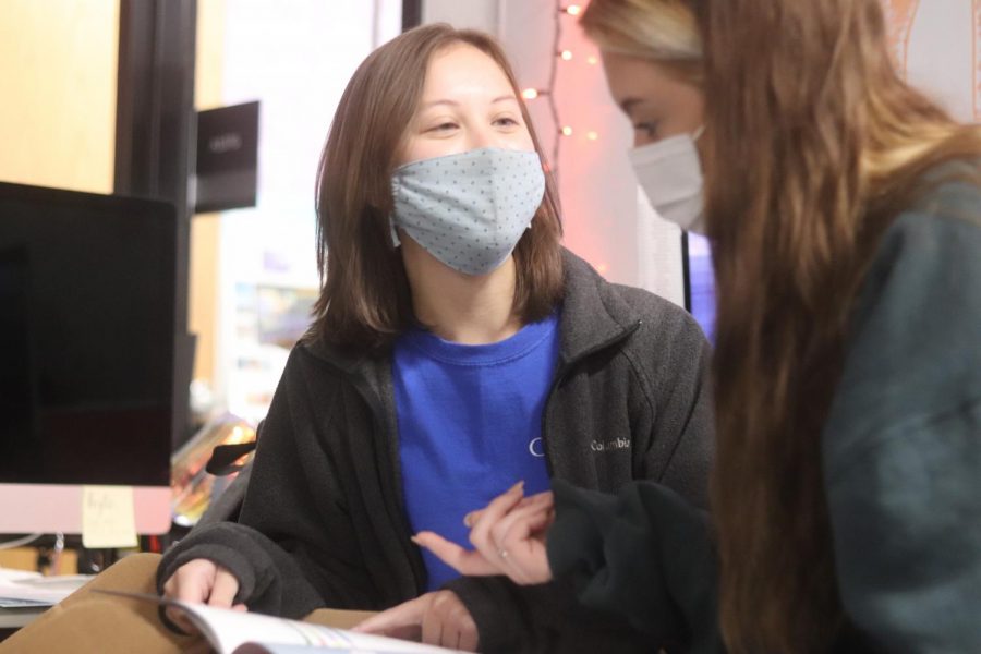 Seniors Riley Shultz and Emily Settle make comments on the color palettes in the 2021 Jostens Yearbook Lookbook in the yearbook room during seventh period on Oct. 1. Shultz is the managing editor for the people and sports section of the Coppell High School yearbook, The Round-Up.