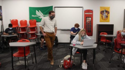 Coppell High School English II teacher Stephen Patino assists CHS sophomore Macy Baume during fifth period in his classroom on Oct. 19. Due to COVID-19, schools in the Dallas-Fort Worth area have had to change their education system to manage COVID-19 cases.