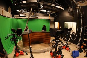 Coppell High School seniors Mark Suante and Hailey Wilkins go over some graphic designs in the  KCBY-TV Studio on Dec. 7. Journalism is allowing students to become increasingly involved in the community. Photo by Lilly Gorman