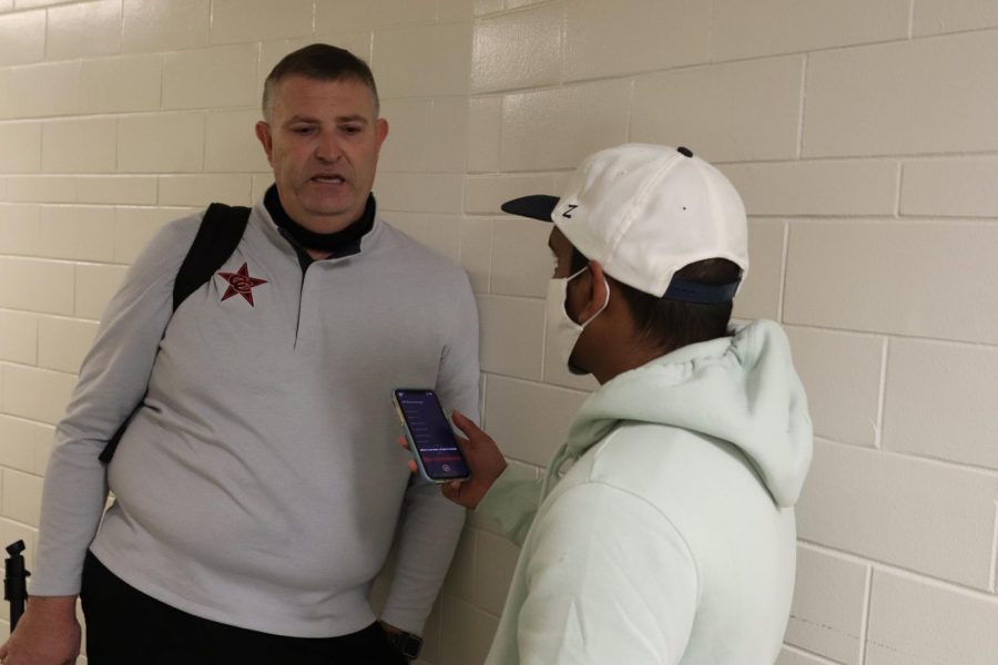 The Sidekick co-sports editor Meer Mahfuz interviews boys basketball coach Clint Schnell after Coppell’s Class 6A area playoff loss against Lake Highlands at Loos Sports Complex on Thursday. While others find sports coverage difficult, Mahfuz thinks sports coverage helps him escape the teenage world.
