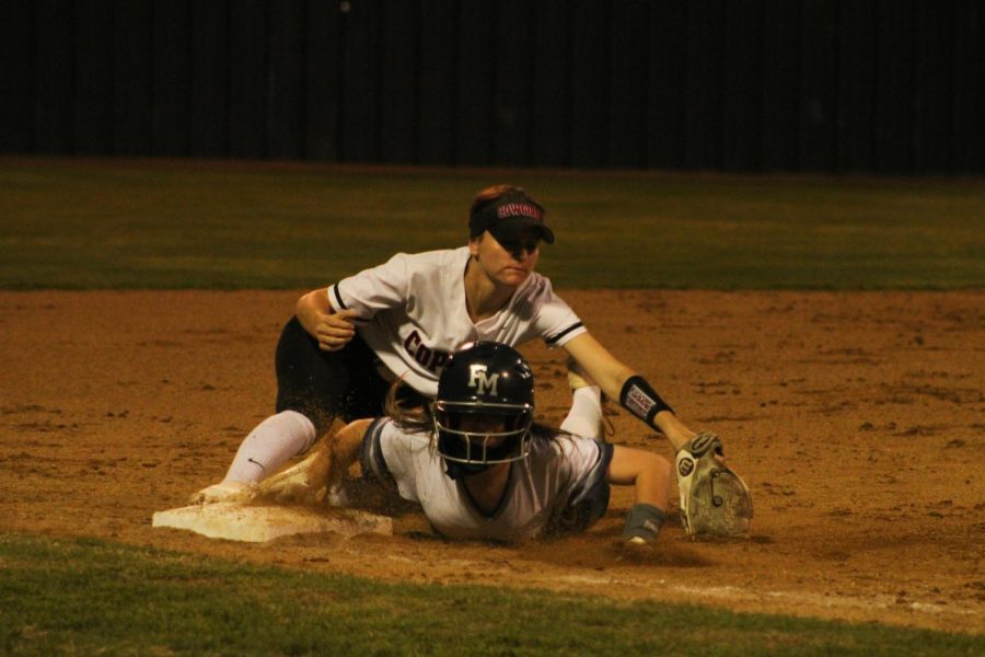 Flower Mound’s Logan Hallman advances to third base against Coppell senior third baseman Reagan Stange on Friday at the Coppell ISD Softball Complex. The Cowgirls fell to the Jaguars, 4-0.