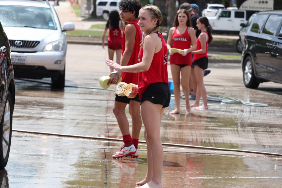 CHS9 student Kyndal Ritch waves forward a round of cars during the Lariettes car wash fundraiser in the Sprouts parking lot on Sandy Lake Road on Saturday. The Lariettes held the car wash to fund their seasonal contest costumes. Photo by Olivia Cooper
