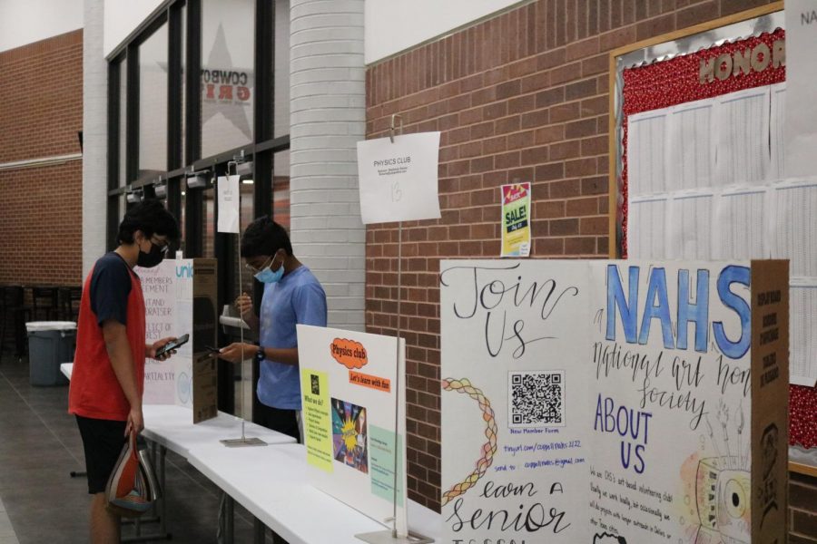 Coppell High School junior Tanai Prathapam encourages sophomore Pranav Cheedala to join UNICEF at the Club Expo during lunch on Friday. The Club Expo was held during all lunches so that students could explore different clubs. Photo by Sannidhi Arimanda