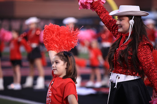 Coppell junior Lariette Madeline Urbina dances in the Lariette spirit line with students from the Lariette junior clinic before the game against Hebron at Buddy Echols Field on Oct. 15. The Cowboys fell to the Hawks, 34-12. Photo by Olivia Short.
