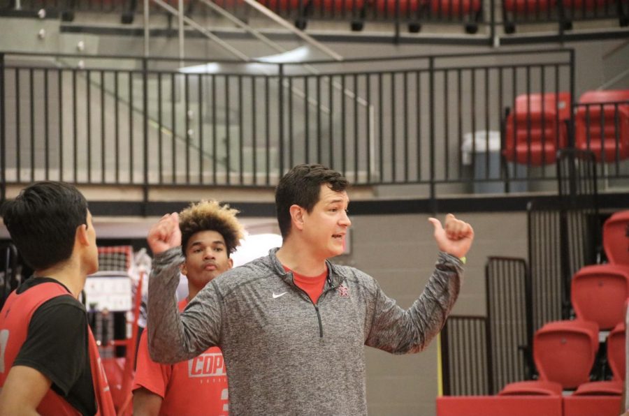 Coppell assistant Nicholas Shaw coaches a defense tactic to the Coppell boys basketball team during practice on Tuesday. Shaw coaches the boys basketball team and teaches ninth grade geography. 