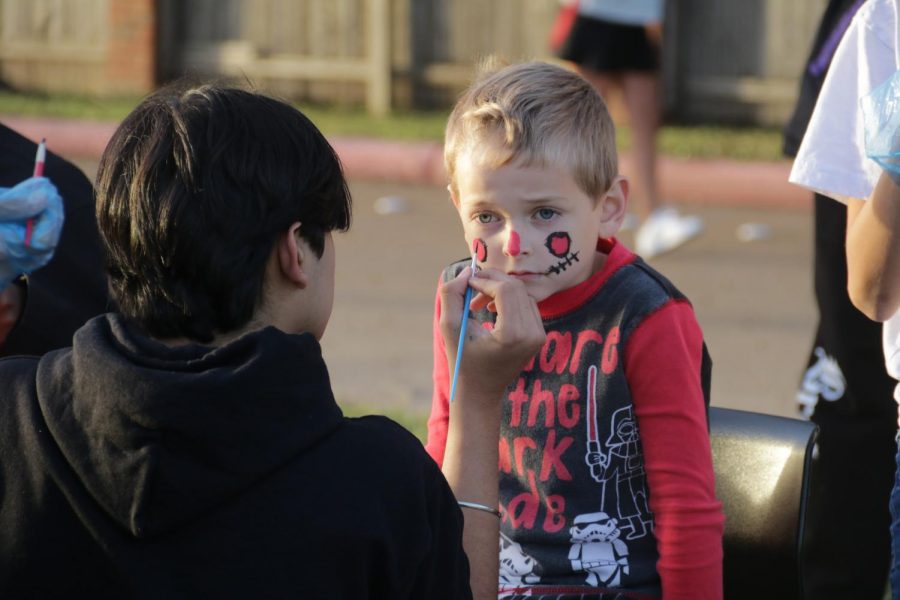 Kindergartner Peter Thurgood gets his face painted into a scarecrow at the Fall Festival at New Tech High @ Coppell on Oct. 28. The Fall Festival is held annually in celebration of Halloween and includes games, food, booths and the annual Punkin’ Chunkin’ event.
