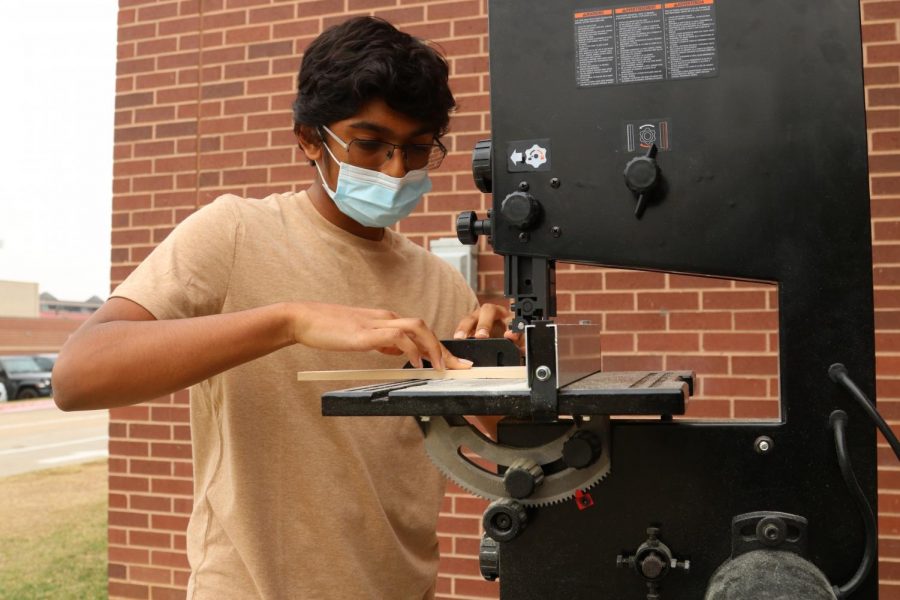 Coppell High School junior Tanai  Prathapam trims a wood block to fit his CO2 dragster for his engineering class during first period on Friday. Prathapam is a UNICEF officer and an aspiring engineer.