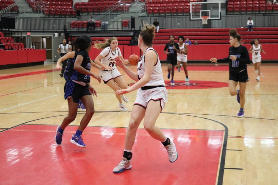Coppell+freshman+guard+Landry+Sherrer+watches+as+Coppell+junior+guard+Jules+Lamendola+dribbles+down+court+at+CHS+Arena+on+Dec.17.+The+Cowgirls+are+in+the+midst+of+a+season+for+the+history+books+while+the+Cowboys+have+completed+a+tough+non-district+schedule+to+hone+in+for+district+play.