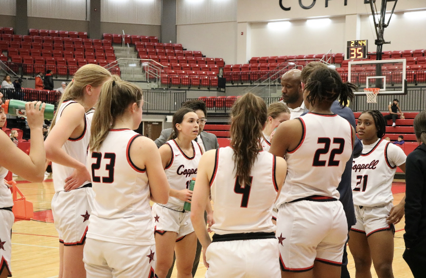 The Coppell girls basketball team huddles after the third quarter at CHS Arena on Friday. The Cowgirls defeated the Farmers, 66-32.
