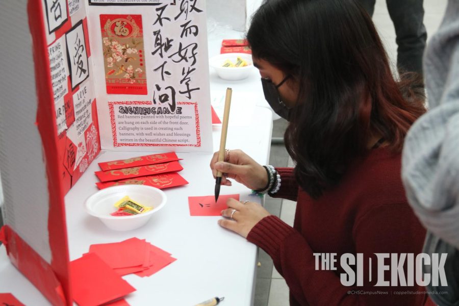 Coppell High School sophomore Saanvi Gourishetti practices calligraphy at the Lunar New Year Exhibition during B lunch on Feb. 10. The Lunar New Year Exhibition was hosted by CHS Chinese teacher Andrea Voelker and her Chinese students to showcase and educate others on East Asian culture and traditions. 