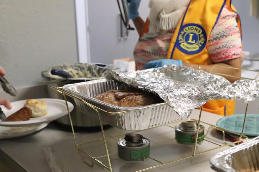 Coppell Lions Club member Roma Pithadiya serves guests gravy and sausage patties at the annual Lions Club pancake breakfast at First United Methodist Church on Saturday. The Coppell Lions Club hosts an annual pancake breakfast where Coppell residents  can purchase raffle tickets and donate blood to Carter BloodCare. 