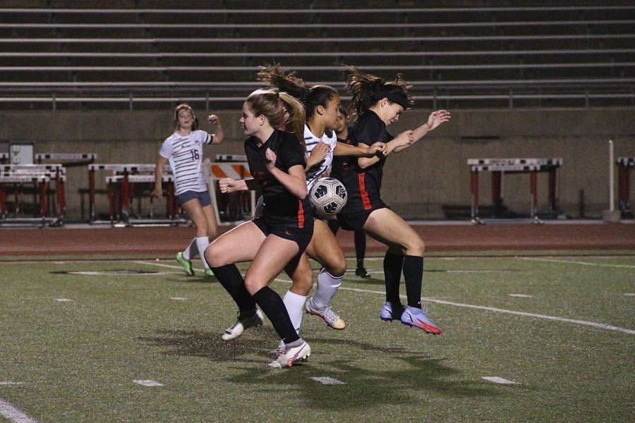 Coppell senior defender Grace Turman and freshmen forward Jordan Clig fight for the ball against Hebron in Tuesdays match at Buddy Echols Field. The Cowgirls won, 2-1, with the first goal in the first six minutes of the first half, and the second goal in the last 10 minutes of the second half. 