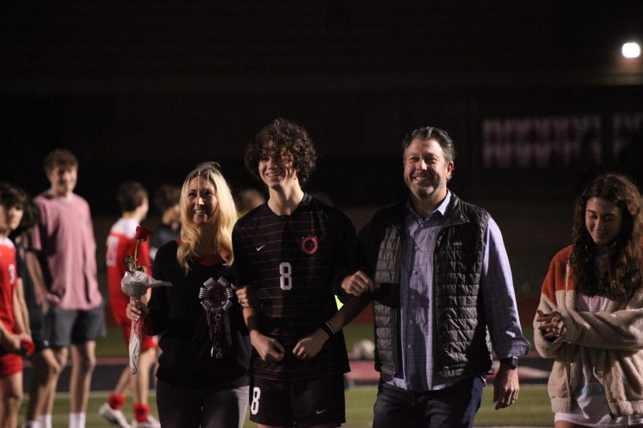 Coppell senior left wing Ethan Frieder walks out with his family during senior night at Buddy Echols Field on Friday. The Cowboys won, 2-1.