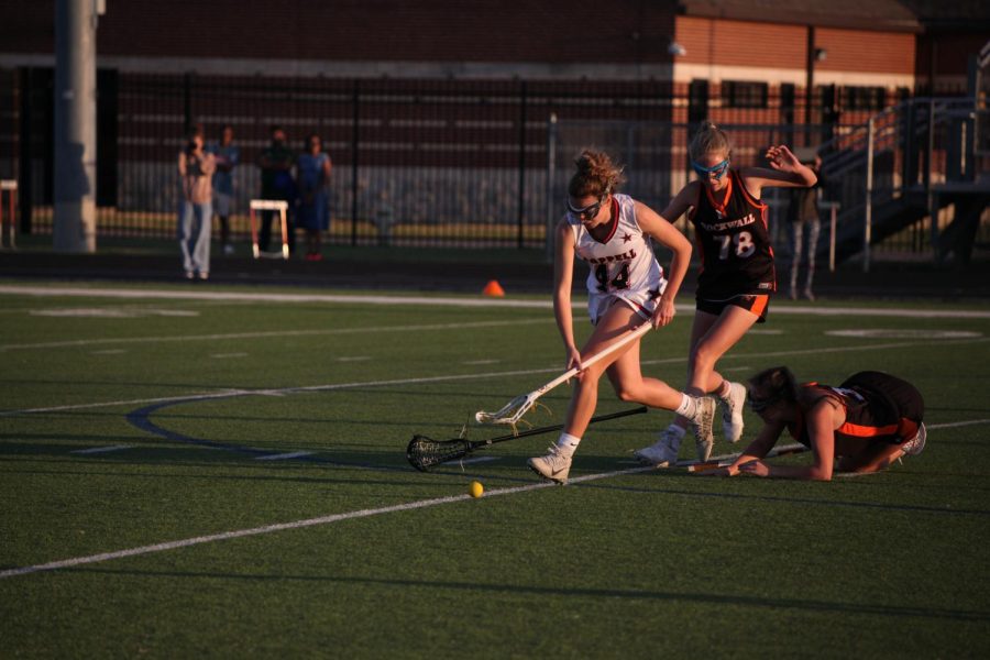 Coppell High School senior Claire Bryant picks the ball up on Thursday at the Coppell Middle School North Field. The Cowgirls beat the Rockwall Yellowjackets 12-11 after going into sudden-death-style overtime. 