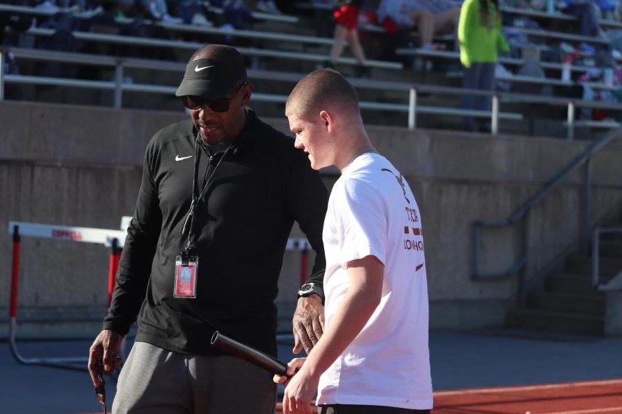 Coppell track coach Eric Hill corrects Coppell junior relay runner Riggs Montgomery on his hand-off form on March 9 at Buddy Echols Field. Hill began coaching at Coppell High School in January. Photo by Olivia Cooper