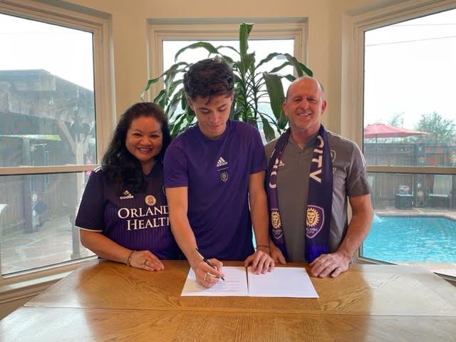Nick Taylor signs a contract with Orlando City SC on Jan. 11 to play professionally in the MLS with his parents Sorya and Randal Taylor. Nick graduated from Coppell High School in 2017 and was a part of the Class 6A 2016 state championship soccer team. Photo courtesy Sorya Taylor 