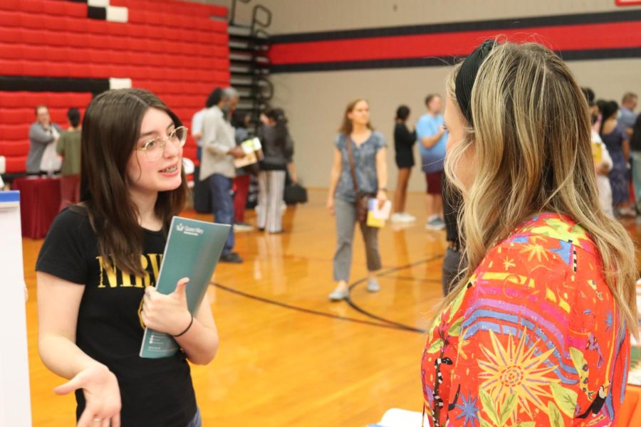 Coppell freshman Marli Field discusses graphic design with Savannah College of Design. Coppell High School hosted the college fair, bringing 200 colleges to its campus.