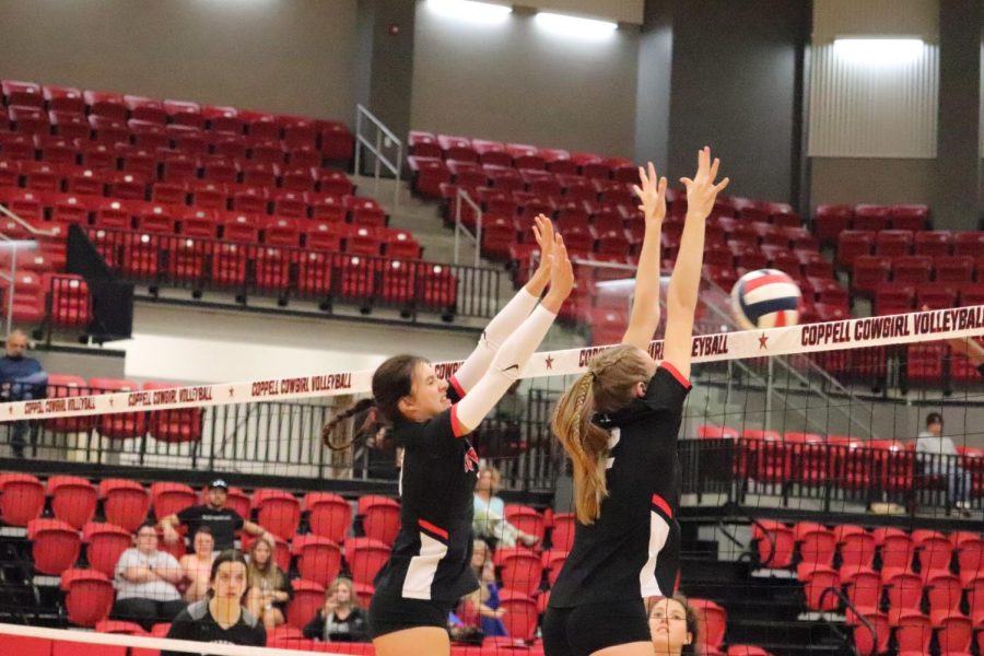 Coppell senior middle blocker Allie Stricker and junior setter Mira Klem block a spike against Denton Guyer at Coppell High School Arena on Aug. 30. The Cowgirls carved out a victory after losing the first set: 16-25, 25-16, 25-23, 25-21.