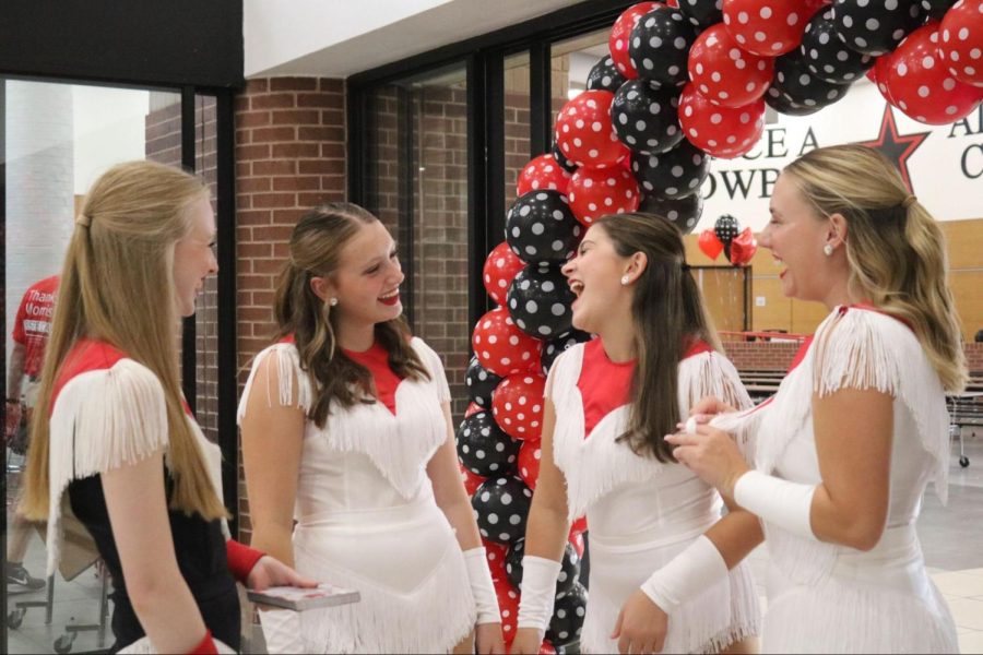 Coppell High School sophomore Lariettes Caroline Leach, Elise Kniff, Tanna Robbins and Payton Hardcastle converse before the Lariettes Spaghetti Dinner commences in the CHS Commons on Friday. The Lariettes Spaghetti Dinner is an annual CHS tradition and fundraiser before the first home football game of the season that features a catered meal, raffle prizes and baked goods. Photo by Shreya Ravi