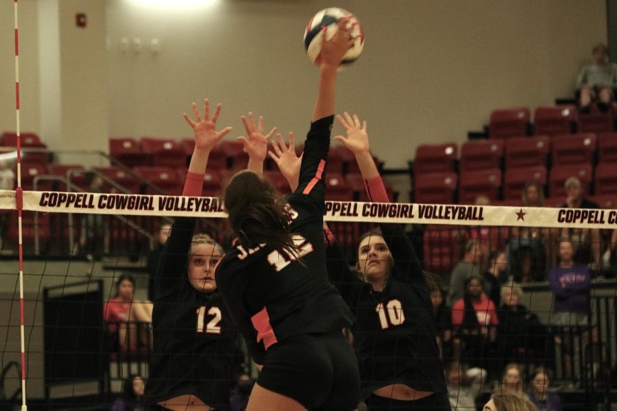 Coppell senior middle blocker Allie Stricker and opposite hitter Madison Travis block Rockwall senior opposite hitter and outside hitter Kyrsten Carrasco at CHS Arena on Friday. The Cowgirls defeated Rockwall, 25-10, 26-24, 25-27, 25-17. 