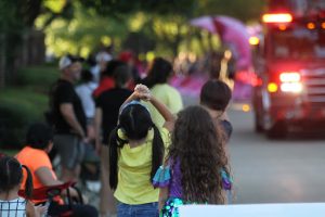 Families get situated on the sidewalk of W. Parkway Boulevard as the Coppell Color Guard approaches during the 2022 Homecoming Parade on Wednesday. The Homecoming Parade returned to the streets of Coppell in 2022, after being disrupted by the COVID-19 Pandemic.