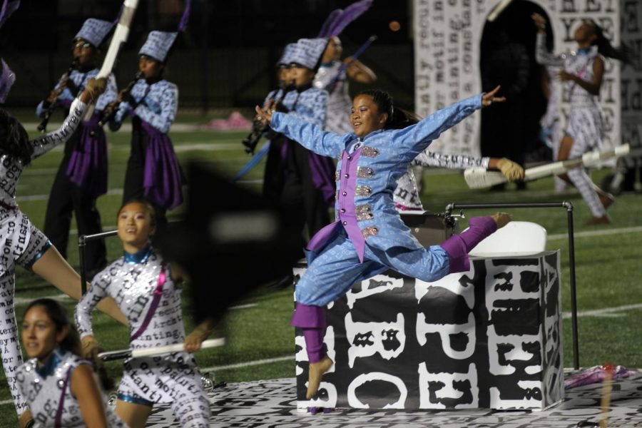 Coppell High School sophomore Madison Tindoc leaps during the finals performance of the Coppell marching show “Archetype” at Pennington Field in Bedford on Saturday. Coppell band placed fourth at the Music for All Bands of America Dallas/Fort Worth Championships with a score of 84.325.
