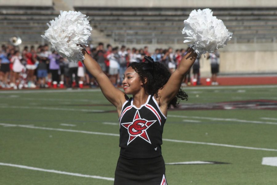 Coppell High School senior cheerleader Sydney Benson welcomes the Coppell football team onto Buddy Echols Field on Sept. 23. Coppell High School held its annual Homecoming pep rally to celebrate various school groups and promote school spirit prior to the game against Plano West.
