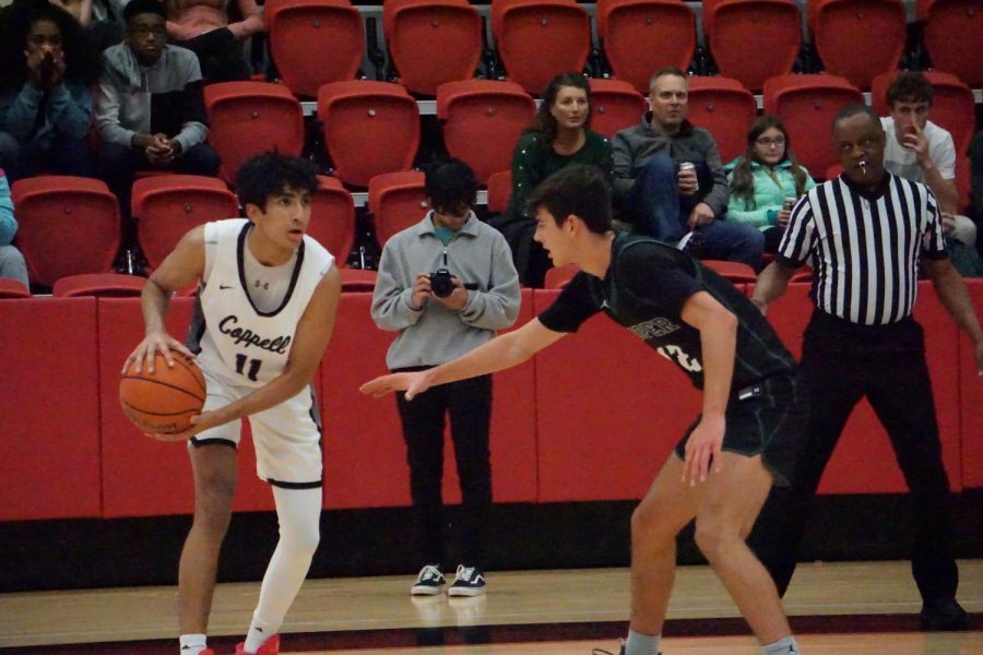 Coppell junior forward Arhan Lapsiwala assumes the triple threat position against Prosper senior guard Brandt Evanson at CHS Arena on Tuesday. Coppell defeated Prosper, 59-57. 